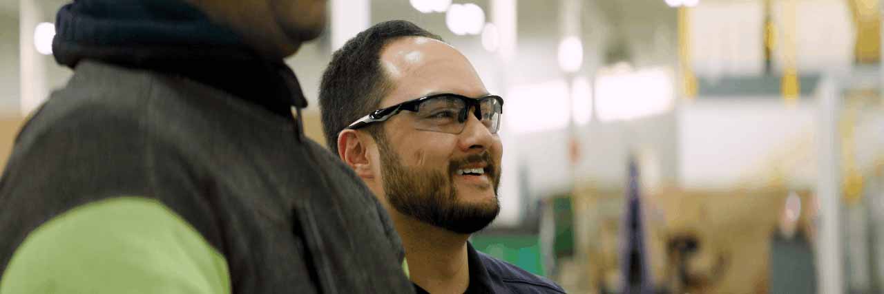 Cardinal CLiC employee smiling with another employee Cardinal CLiC employee smiling with another employee